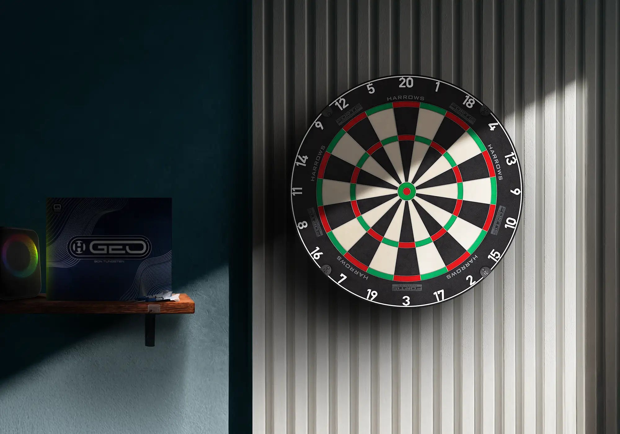 A wall-mounted fortis dartboard with black, white, red, and green scoring sections, shown against a gray corrugated wall with sunlight streaming in from the right. A dark blue shelf with a box on the left is partially visible.